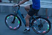 Man riding illuminated bicycle