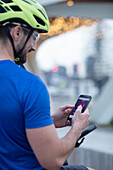 Man in bike helmet using smartphone