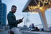 Man using smartphone in city at night