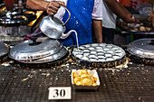 Zubereitung von Kokospfannkuchen auf dem Nachtmarkt in Thailand