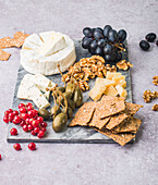 Cheese platter with crispbread, capers, currants, grapes and nuts