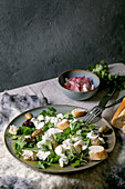 Salad with tattered mozzarella buffalo, olives and greens