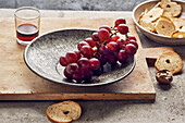 Still life with red grapes, walnuts, bread chips and red wine