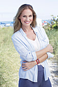 Long-haired woman in spring-like blue and white outfit on the beach