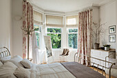 Bright bedroom with bay window and metal bed frame