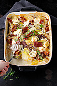 Potato gratin with dried tomatoes, red onion and thyme