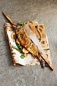 Skewered whole fish with herbs, salt, and lemon