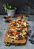 Grilled pizza flatbread with tomatoes, herbs, and capers