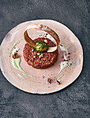 Tandoori beef tartare with two kinds of kefir, pancetta ring and egg yolk