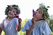 Girls with flower wreaths eating popsicles