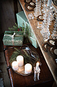 Glass candle holder on wooden table, Christmas decorations and gift on vintage chest