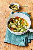 Vegetable noodle soup with pesto garnish