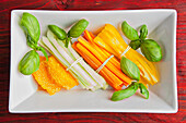Raw vegetables with oranges and basil