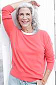 Mature woman with grey hair in salmon jumper