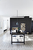 Large dining table made of old wood with designer chairs, and a fireplace with firewood storage in the background