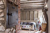 Rustic living room with old stove, wooden beamed ceiling and sofa