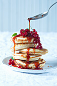 Mini-Pancakes mit Honig und roten Johannisbeeren
