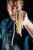 Hobby chef holding fresh tagliatelle pasta