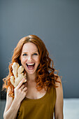 Portrait of excited redheaded woman with ginger root