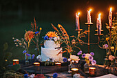 Wedding cake on table with candles outdoors