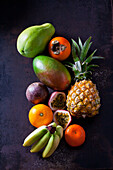 Tropische Früchte auf dunklem Grund