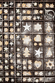 Homemade Christmas cookies, stars and Christmas baubles in old wooden typecase