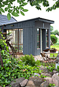 A self-built greenhouse, with vintage garden furniture out front