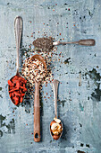 Spoons of black chia seeds, wolfsberries, nuts and quinoa