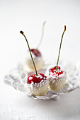 Cherries covered with white chocolate and grated coconut in bowl