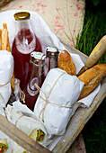 Picnic basket with bread, juice, and wrapped delicacies