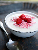 Cold buttermilk dessert with cream and raspberries
