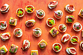 Tartelettes with mozzarella, pea puree, peppers, pesto, red onions and tomatoes
