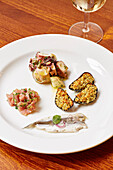 A selection of seafood antipasti, breaded mussels, tuna, anchovy and octopus