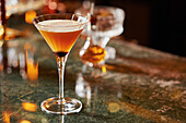 An orange cocktail in a martini glass