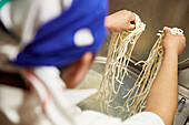 Udon noodles being lowered into boiling water
