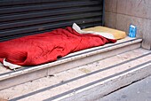 Homeless person's bed in a Paris doorway