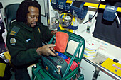 Medical technician preparing equipment in an ambulance