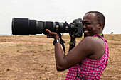 Masai field guide taking pictures with a telephoto lens