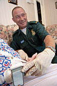 Paramedic holding elderly patients hand