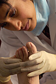 Podiatrist examining the foot of a young patient