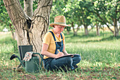 Farmer writing notes in walnut orchard