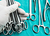 Gloved hand holding surgical instruments