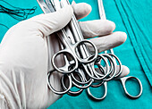 Gloved hand holding surgical instruments