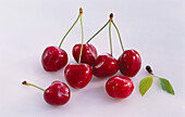Fresh cherries with leaves on white background