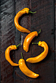 Yellow hot peppers on a dark wooden background