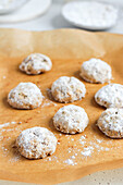Pecan biscuits with icing sugar on baking paper