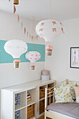 DIY hot air balloons in children's room with bookshelf and bed