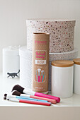 Make-up brushes and storage boxes on a white background