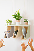 Hanging shelf with plants and books as a creative room decoration