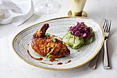 Crispy skin chicken leg with pickled cucumber and red cabbage